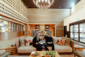 Family relaxing in the lobby of MTN House, a modern mountain lodge.