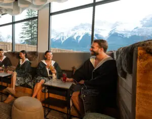 Guests relax with drinks in The Elements Lounge with mountain views.