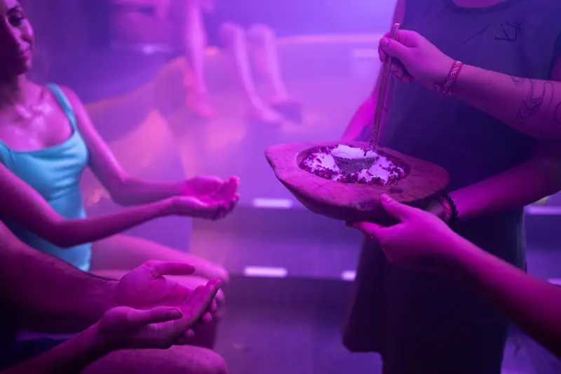 Hands offering a wooden bowl of herbs for a herbal steam cleanse