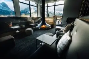 Cozy mountain lodge lounge with fireplace and panoramic windows.