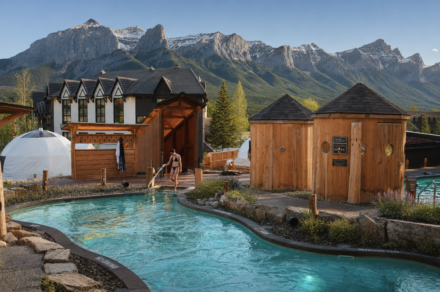 Cold plunge pool with wooden saunas and snowy mountains